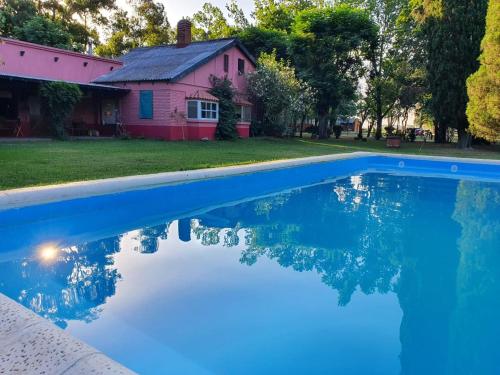 una casa con piscina frente a una casa en Quinta Maria en Lobos