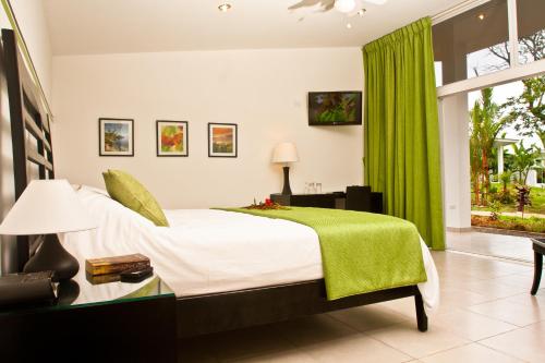 a bedroom with a bed and a green curtain at Bocas del Mar in Boca Chica