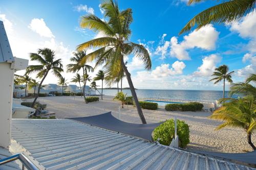 una playa de arena con palmeras y una rampa de skate en Deja Blue - Comfortable Beachfront condo, en Marigot