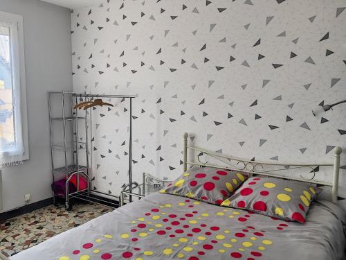 - une chambre dotée d'un lit avec des oreillers couleur polka dot dans l'établissement Maison de plain-pied avec terrasse, centre ville, à 150m de la plage - FR-1-361-334, à Jullouville