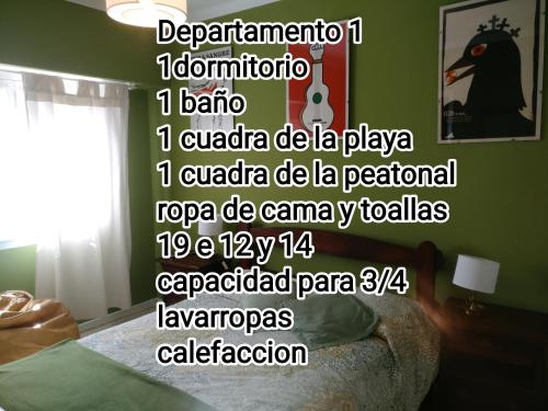 a room with a bed with a poster on the wall at Departamento Legarra Mar in Miramar