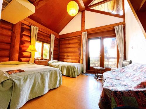 白馬的住宿－Hakuba Pension & Log Hotel Meteor，小木屋内一间卧室,配有两张床