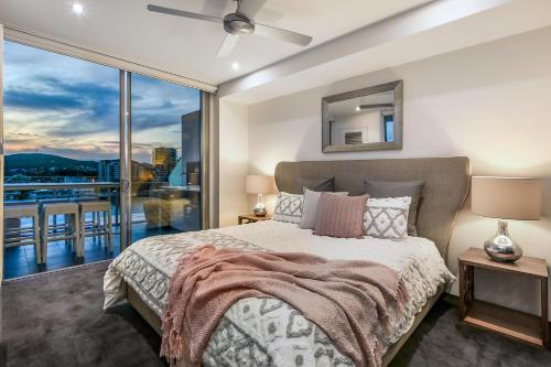 - une chambre avec un lit et une grande fenêtre dans l'établissement Stunning Waterfront Penthouse 3 or 4 Bedrooms, à Brisbane