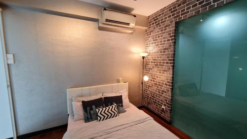 a bedroom with a bed with a brick wall at Premium 5STAR Resort Suite Mid Valley KL Sunway by Stayz Suites with Shopping Complex in Kuala Lumpur