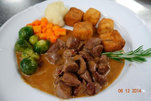 a plate of food with meat and vegetables and gravy at Gasthof Löwen in Melchnau