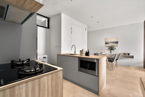 a kitchen with a sink and a stove top oven at Lumi Tropicana in Petaling Jaya