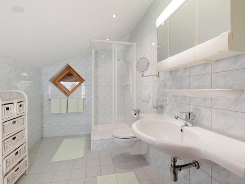 a white bathroom with a sink and a toilet at Ferienwohnungen Haid in Oetz