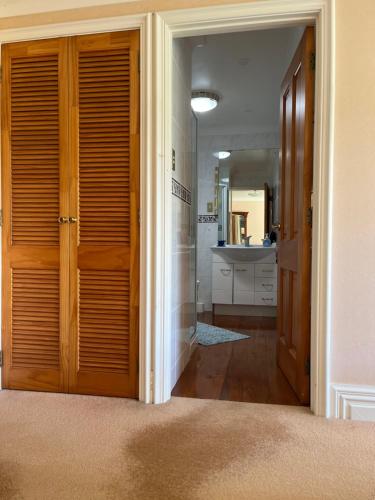 a hallway with a door leading to a bathroom at Tamaterau Seaview House in Whangarei in Whangarei