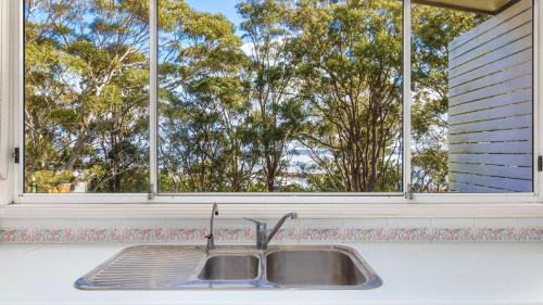 - un évier de cuisine devant une fenêtre dans l'établissement Bay Escape, à Nelson Bay