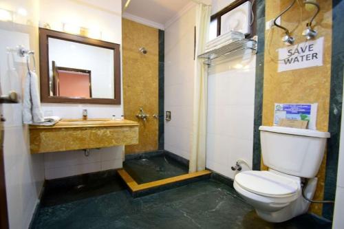 a bathroom with a toilet and a sink and a mirror at Goroomgo Marc Shimla Near Mall Road - Luxury Room - Excellent Service - Ample Parking - Best Hotel in Shimla in Shimla