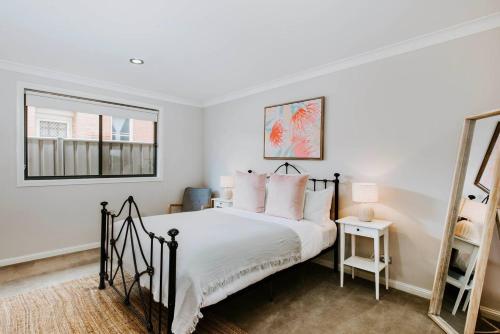 a bedroom with a black and white bed and a mirror at Gladstone Blush - Premium Comfort in Mudgee's Heart in Mudgee