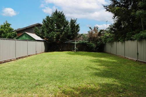 a backyard with a fence and a grass yard at Gladstone Blush - Premium Comfort in Mudgee's Heart in Mudgee
