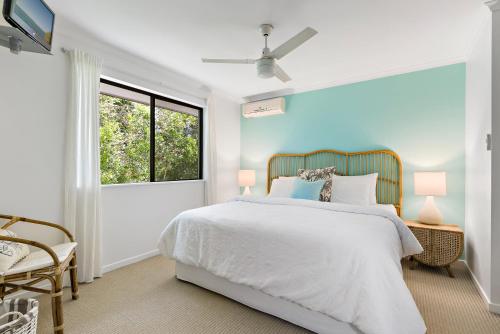 ein Schlafzimmer mit einem weißen Bett und einem Fenster in der Unterkunft Modern & Stylish 2 Bedroom Townhouse in Noosaville