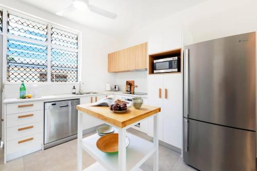a kitchen with a stainless steel refrigerator and a wooden table at 'Botanica Fresca' Chic Nightcliff Convenience in Darwin
