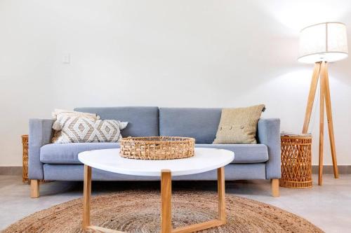 a living room with a blue couch and a white table at 'Botanica Fresca' Chic Nightcliff Convenience in Darwin