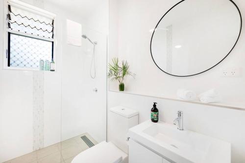 a white bathroom with a sink and a mirror at 'Botanica Fresca' Chic Nightcliff Convenience in Darwin