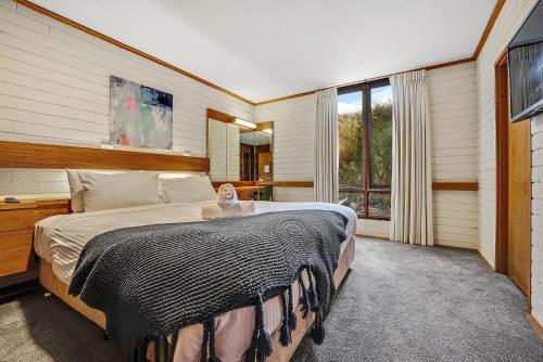 a bedroom with a large bed and a large window at Grey Kangaroo On Lake Jindabyne foreshore in Jindabyne