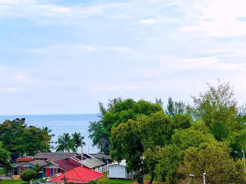 a group of houses and trees with the ocean in the background at D'Mentari Laguna Super Seaview in Port Dickson