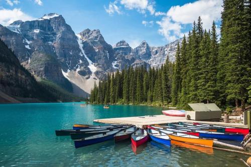 a group of boats on a lake in the mountains at Incredible Mountain View Townhouse in DT Canmore w/ A/C & U/A Parking in Canmore