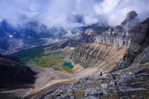 a person standing on top of a mountain at Incredible Mountain View Townhouse in DT Canmore w/ A/C & U/A Parking in Canmore