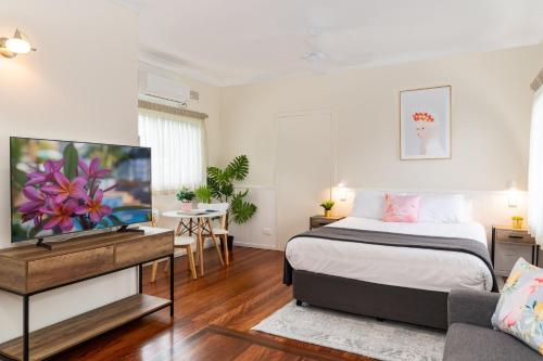 a bedroom with a bed and a tv and a couch at Pacific Motel 03 in Forster