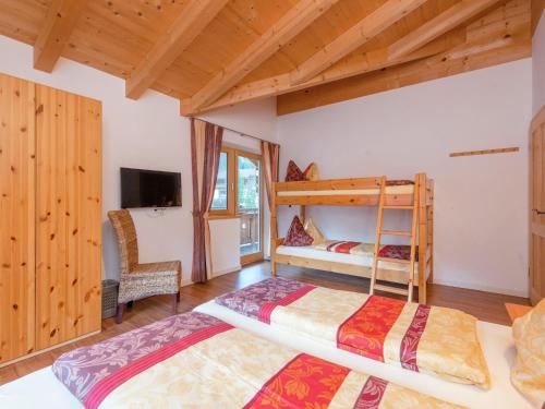 a bedroom with two bunk beds and a tv at Chalet Wasserfall, Krimml in Krimml