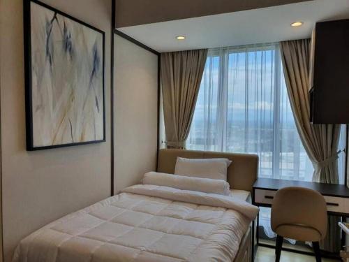 1 dormitorio con cama, escritorio y ventana en BRANZ BSD Luxury & comfort at ICE BSD en Samporo