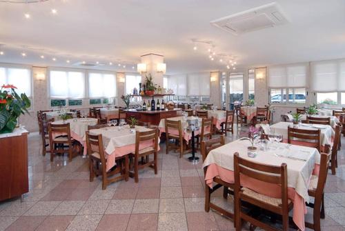 jadalnia ze stołami i krzesłami oraz restauracja w obiekcie Hotel Lido w mieście Deiva Marina