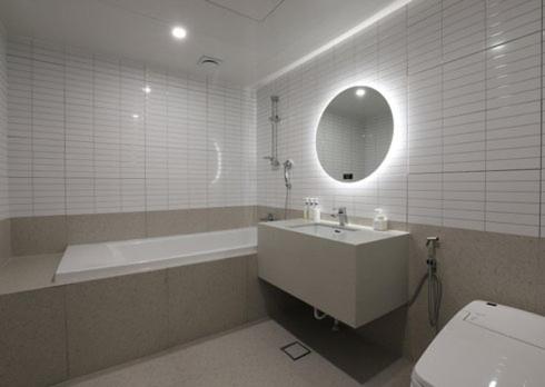 a bathroom with a sink and a tub and a toilet at H Avenue Hwamyeong in Busan