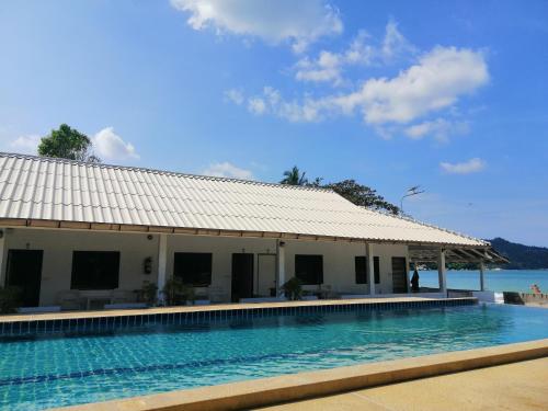 a swimming pool in front of a building with the ocean in the background at Thong Nai Pan Beach Resort in Thong Nai Pan Yai