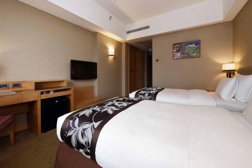 a hotel room with a large bed and a television at Fullon Hotel Hualien in Hualien City