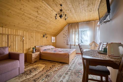 ヤブルニツァにあるTsaryna Sadybaのベッドルーム1室(ベッド1台、ソファ、テーブル付)