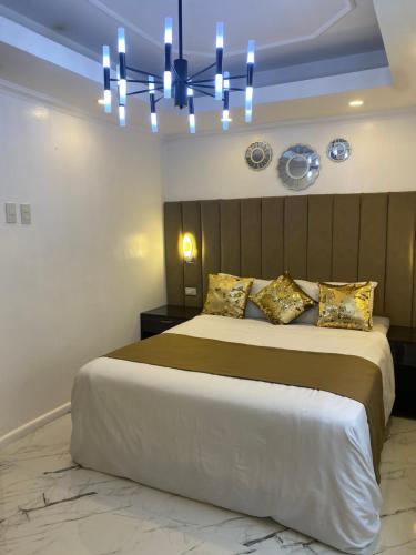a bedroom with a large bed and a chandelier at MAKATI Isabela Luxury in Manila