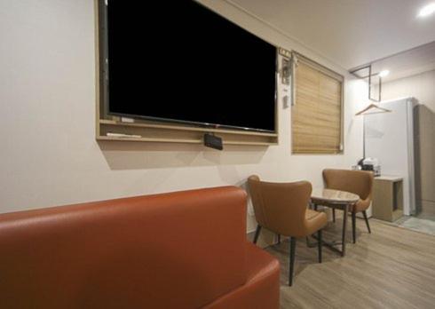 a living room with a large flat screen tv on the wall at H Avenue Hwamyeong in Busan