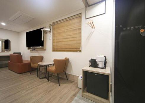 a hospital room with a table and chairs and a tv at H Avenue Hwamyeong in Busan