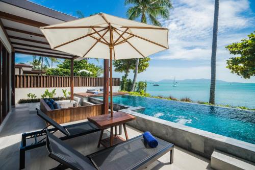 - une terrasse avec une table et un parasol à côté de la piscine dans l'établissement Peace Resort Samui, à Bophut 