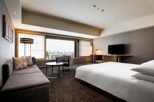 a hotel room with a bed and a large window at The Capitol Hotel Tokyu in Tokyo