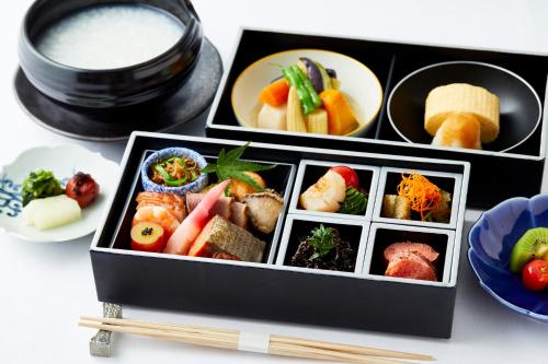 two boxes filled with sushi and other food items at The Capitol Hotel Tokyu in Tokyo