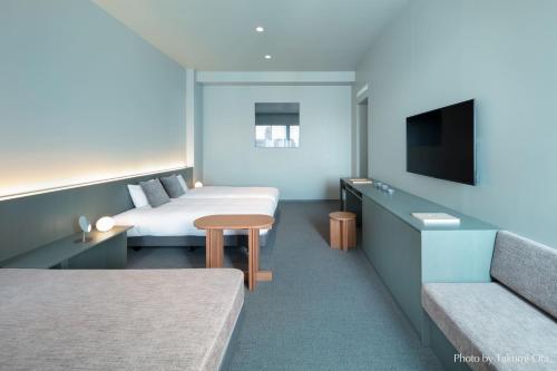 a hotel room with two beds and a flat screen tv at KAIKA TOKYO by THE SHARE HOTELS in Tokyo