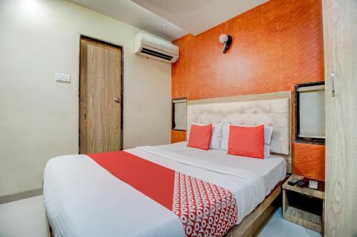 a bedroom with a large bed with red pillows at OYO 67027 Grace Inn in Mumbai