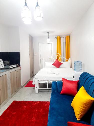 a living room with a bed and a blue couch at GCurtway Homes Tsavo Superior Studios in Nairobi