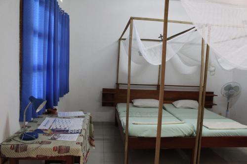 a bedroom with a bunk bed and a table at Centre Lucien Botovasoa in Diego Suarez