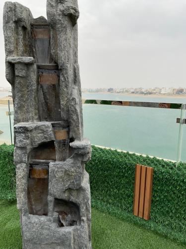 a stone water fountain in front of a building at منتجع اووه يامال البحري في الخيران OOh Yaa Mal in Al Khīrān