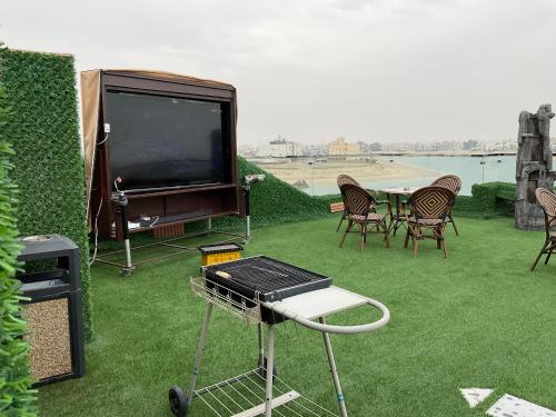 a patio with a tv and a table and chairs at منتجع اووه يامال البحري في الخيران OOh Yaa Mal in Al Khīrān