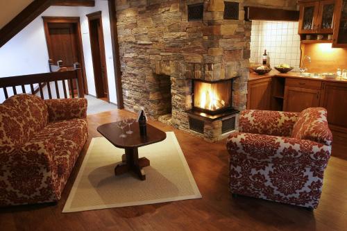 a living room with two chairs and a fireplace at Vila GRAND in Smokovce