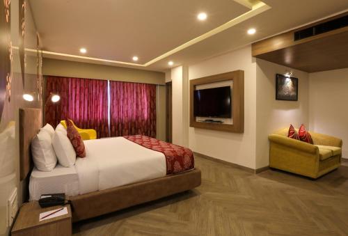 Mango Hill Central Chennai في تشيناي: غرفه فندقيه سرير وتلفزيون