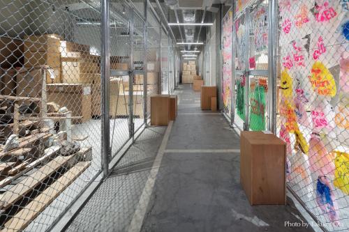 an empty aisle of a barn with animal cages at KAIKA TOKYO by THE SHARE HOTELS in Tokyo