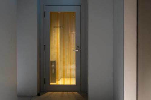 an open door with a window in a room at KAIKA Tokyo by THE SHARE HOTELS in Tokyo