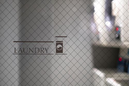 a sign on a door with a camera on it at KAIKA Tokyo by THE SHARE HOTELS in Tokyo