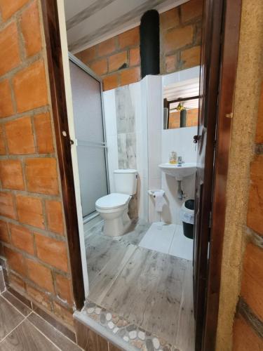 a bathroom with a toilet and a sink at Estadero y Hospedaje las Pavas in Norcasia